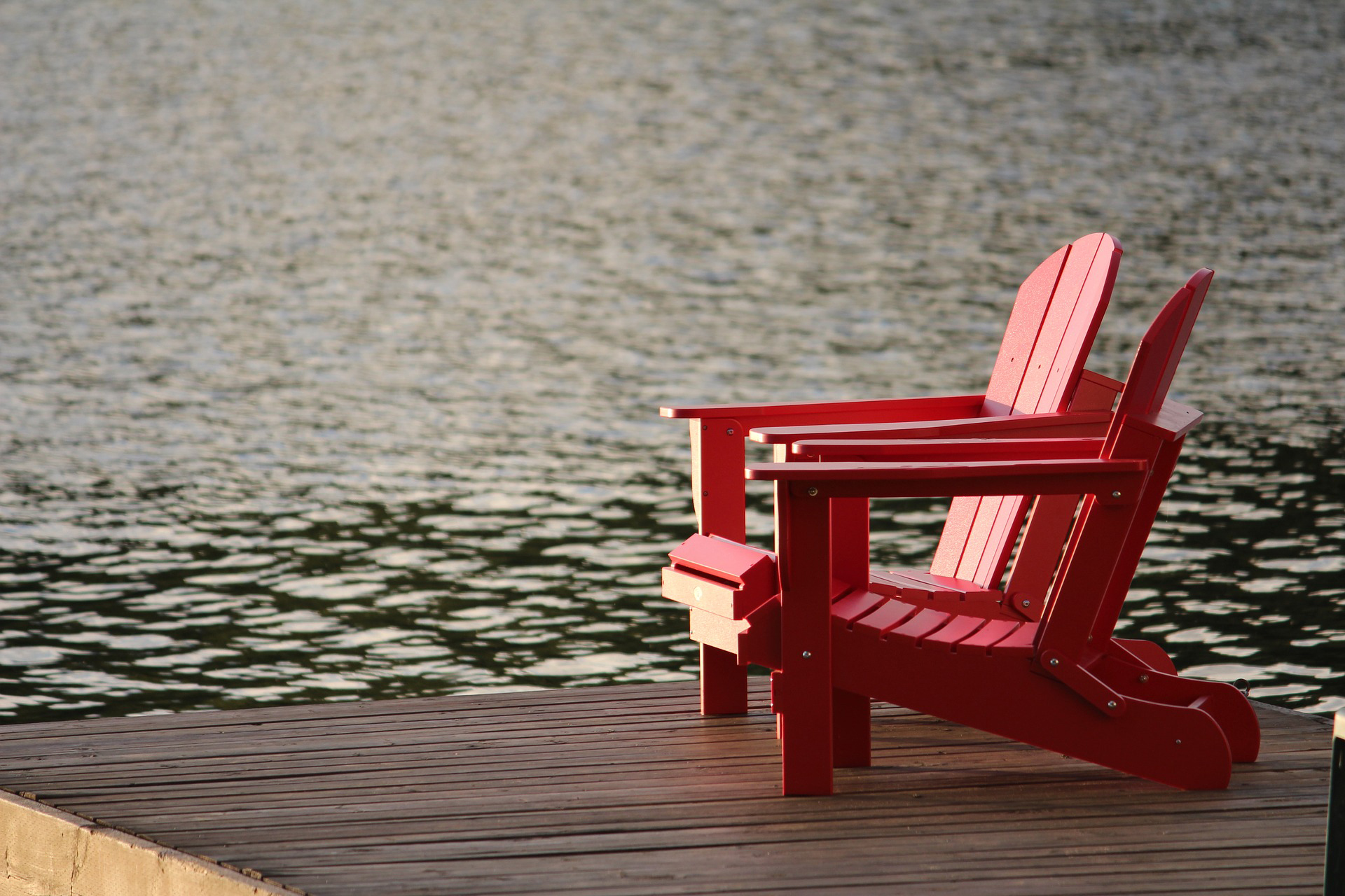 Red chair on dock facing a lake