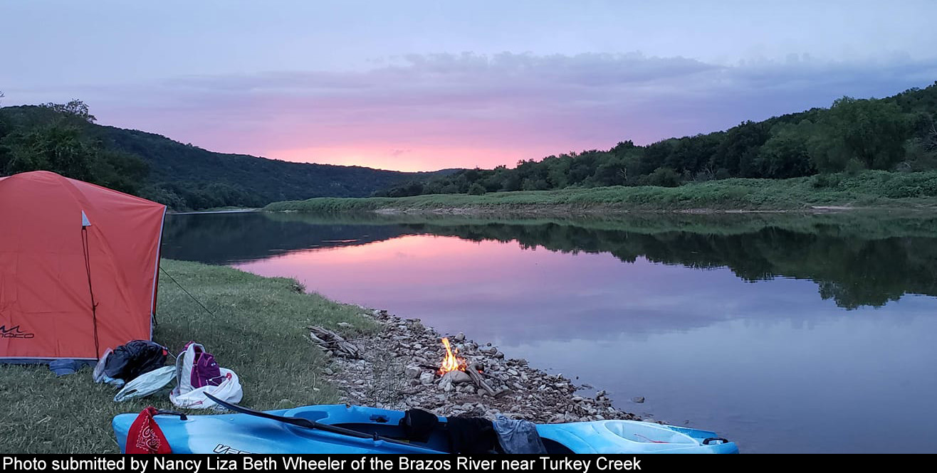 Camping gear highlighted by the setting sun over the Brazos River