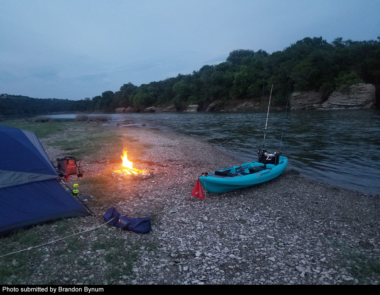 Tent and campfire along river