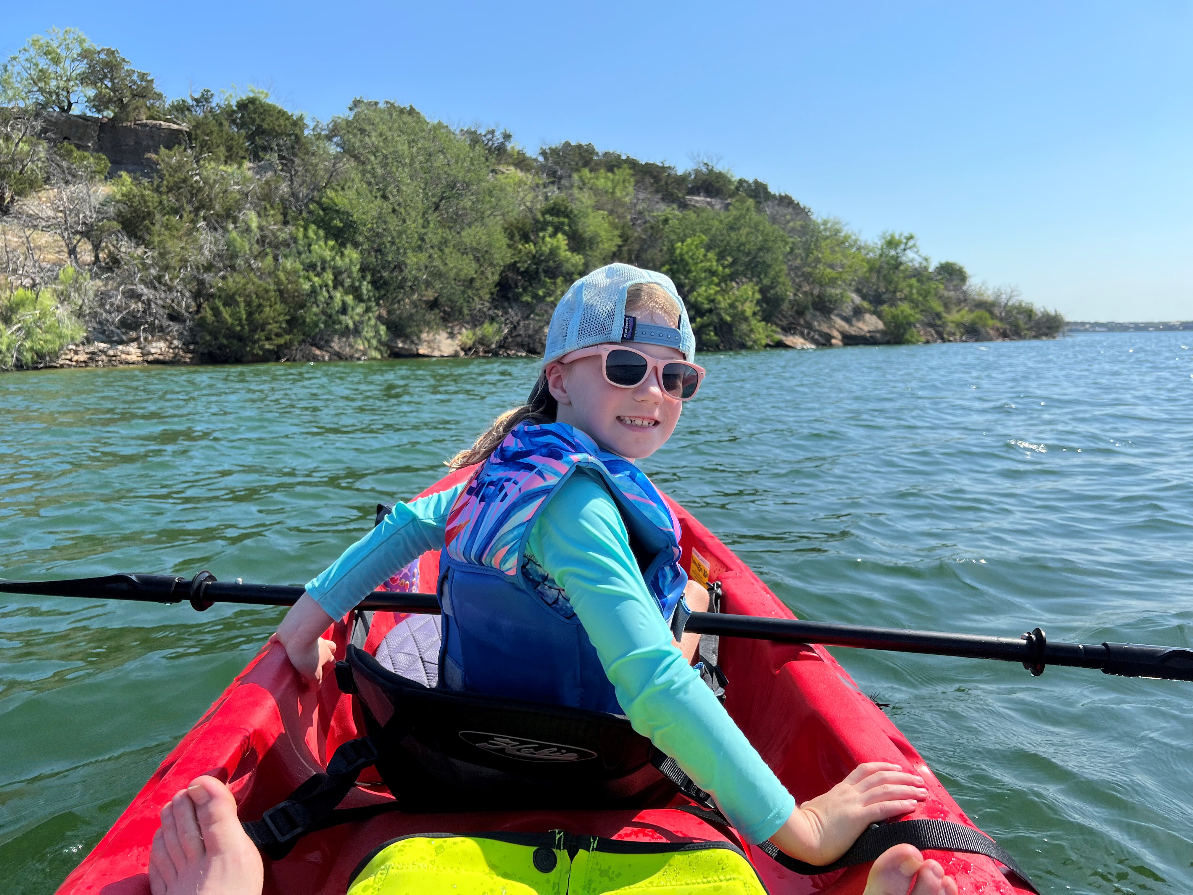 A girl smiling in a kayak on the lake