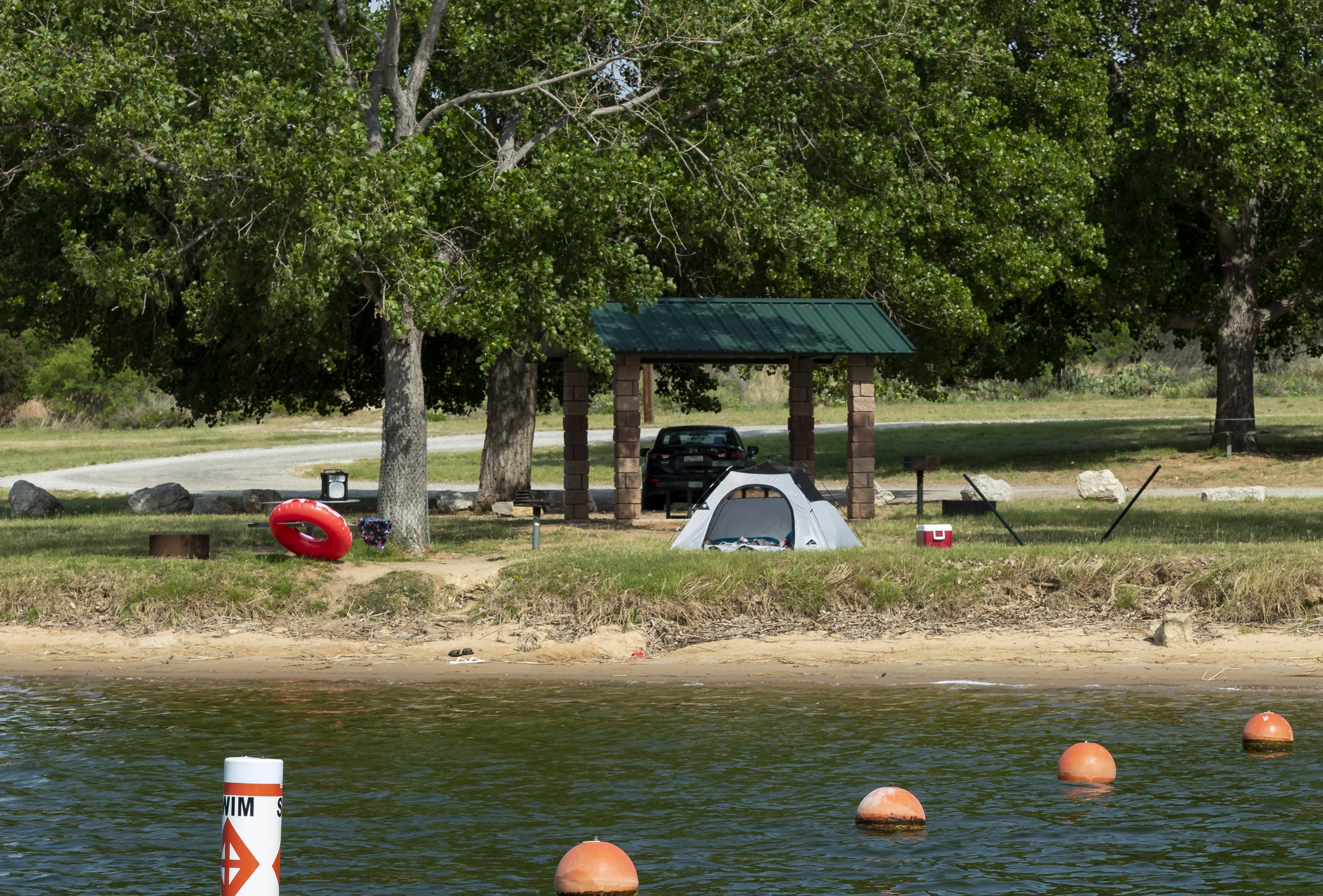 A tent at a park by a body of water